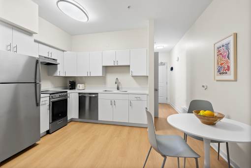 A modern kitchen with a table and chairs.