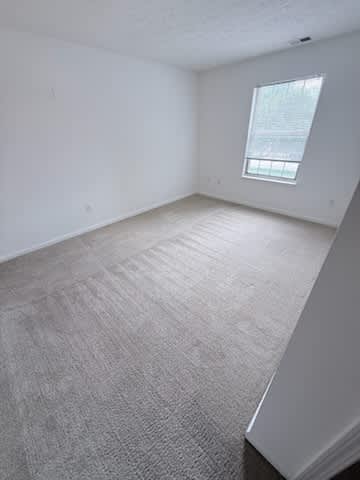 Waterford Court SN1 Bedroom. A room with a carpeted floor and a window.
