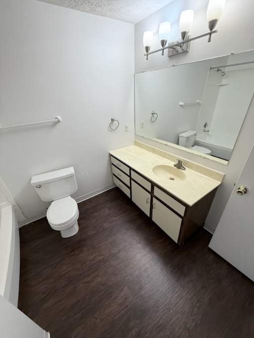 Waterford Court SN1 Bathroom. A white toilet sits next to a sink in a small bathroom.