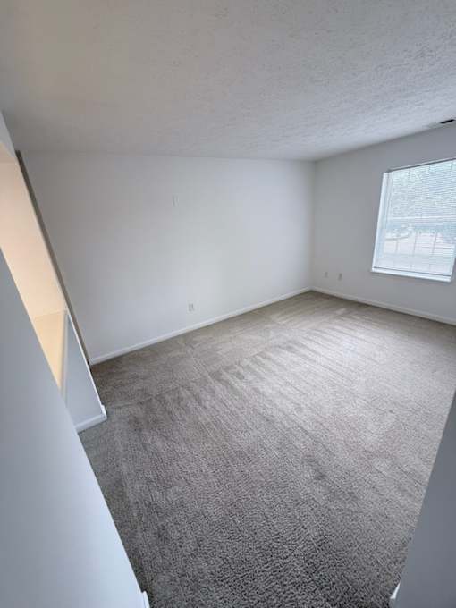 Waterford Court SN1 Bedroom A room with a carpeted floor and a window.