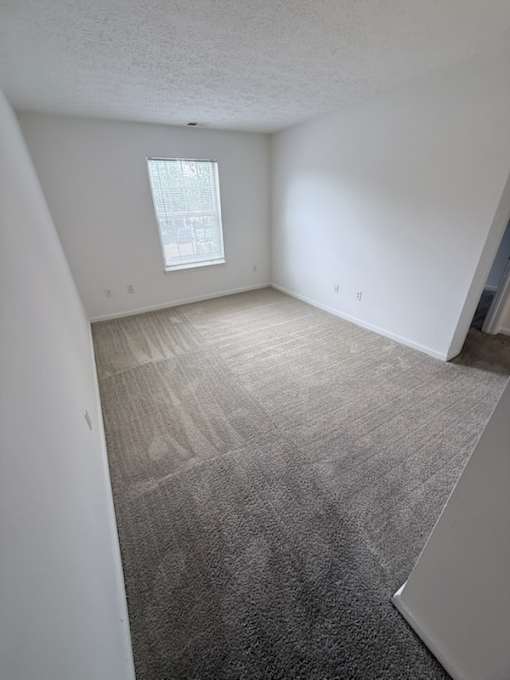 Waterford Court SN1 Bedroom. A room with a carpeted floor and a window.
