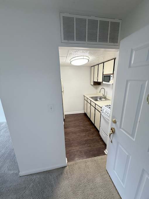 Waterford Court SN1 Kitchen. A kitchen with white appliances and a white door.