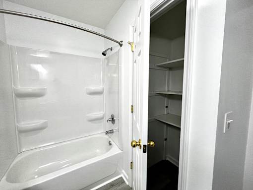 A white bathroom with a walk in shower and a white bathtub.