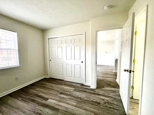 A room with a white door and a window.