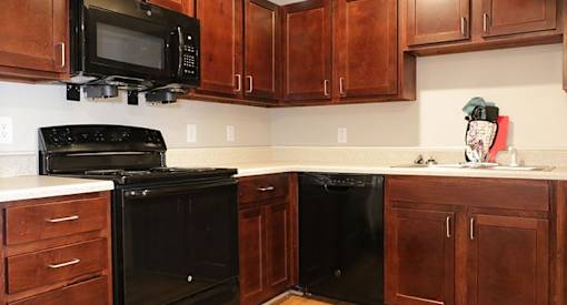 a kitchen with black appliances and wooden cabinets