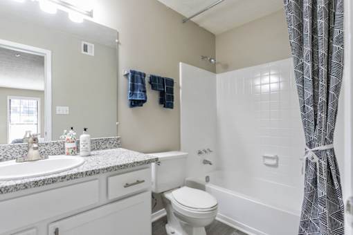 A bathroom with a white toilet, sink, and bathtub.