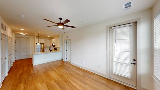 A room with a ceiling fan and wooden floors.