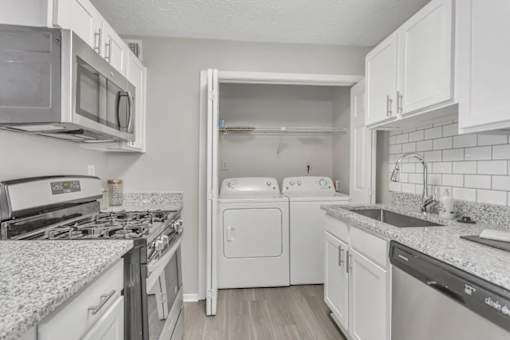 A kitchen with white cabinets and appliances.