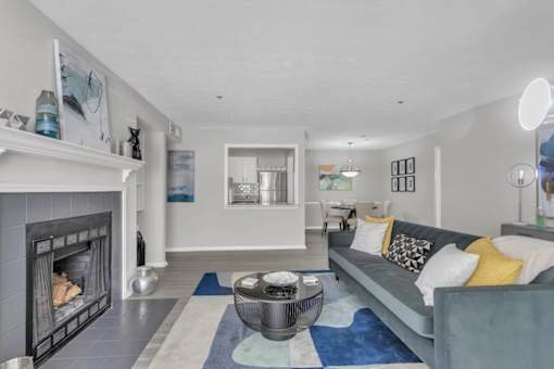 A modern living room with a fireplace and a grey couch.