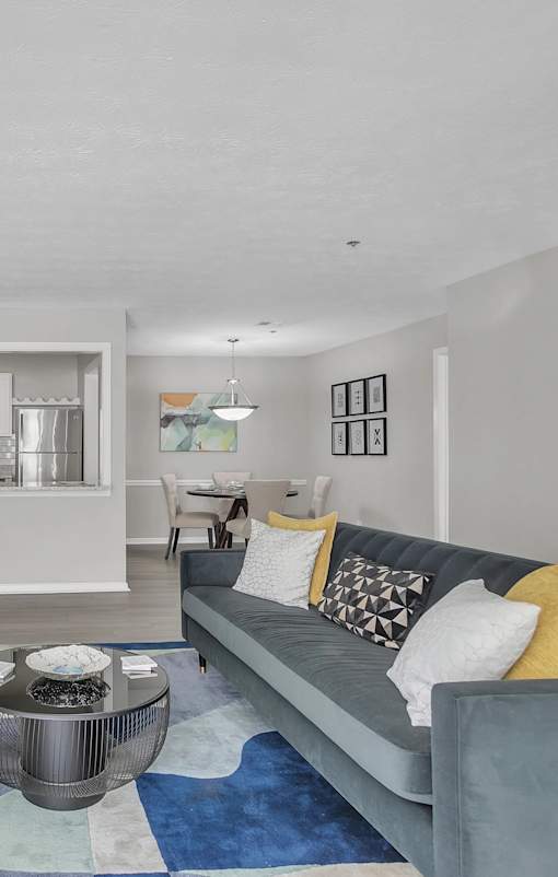 A grey couch with a coffee table in front of it.