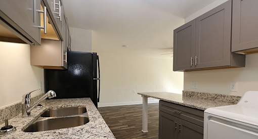 affordable section 8 stone mountain a kitchen with a sink and a black refrigerator