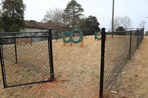 a park with a chain link fence and some playground equipment