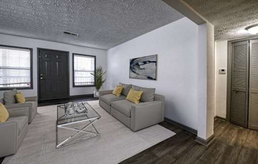 the living room of an apartment with a couch and a glass coffee table