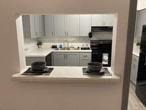 a kitchen with white cabinets and a counter with two bowls on it