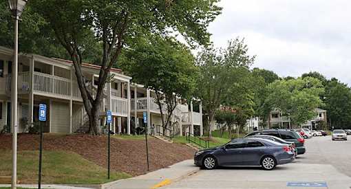 a row of cars parked in front of an apartment building