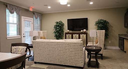 a living room with a couch and chairs and a television