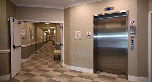 a hallway of elevators in a hospital lobby
