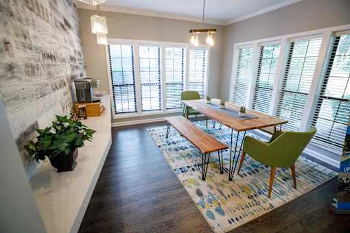 a dining room with a wooden table and green chairs
