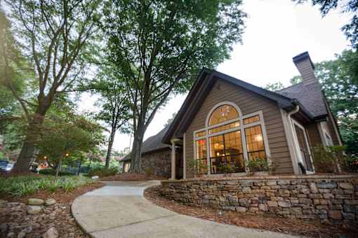 decatur luxury living the front of a house with a walkway and a stone wall