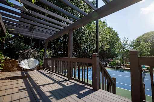 a decatur luxury living backyard deck with a swing and a tennis court