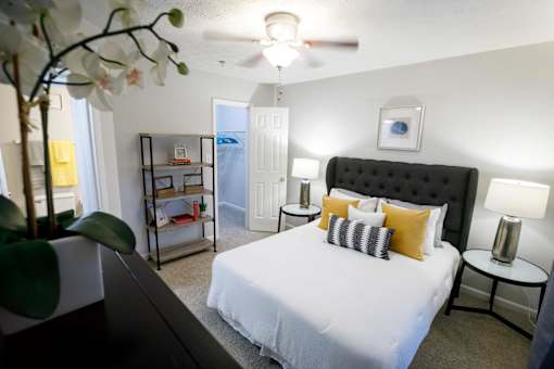 a bedroom with a large white bed and a ceiling fan decatur luxury living