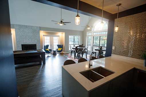 an open kitchen and living room with a piano and a dining table