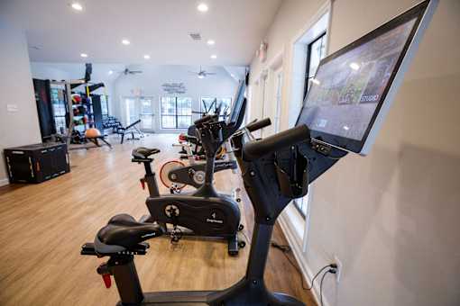 a gym with various exercise machines and a flat screen tv