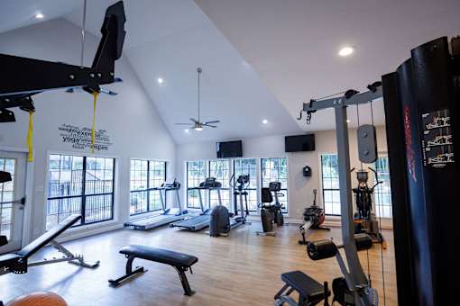 a gym with a lot of exercise equipment and windows