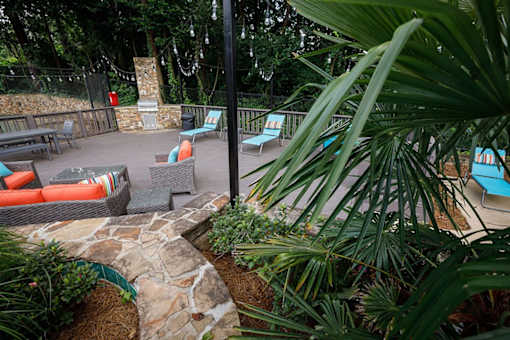 a patio with couches and chairs in a garden