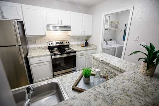 a kitchen with granite counter tops and stainless steel appliances