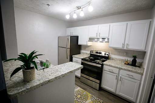 a kitchen with white cabinets and stainless steel appliances