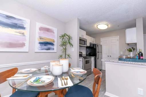A dining room with a glass table set for two.