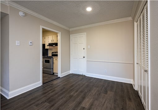 A kitchen area with a white door and a small fridge.