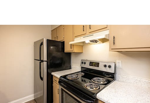 A black stove and refrigerator in a kitchen.