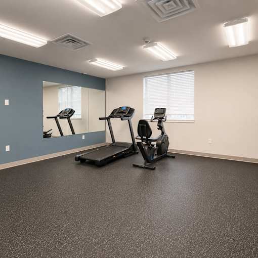 A spacious gym with treadmills and elliptical machines.