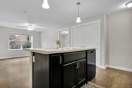 A kitchen with black appliances and white cabinets.