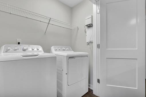 Two white washing machines in a laundry room.