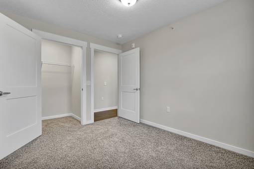 A room with two white doors and a carpeted floor.