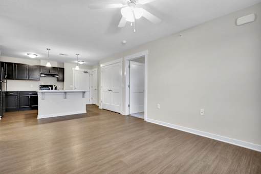 A spacious kitchen with a white countertop and a ceiling fan.