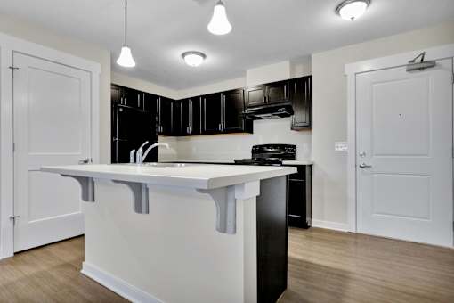 A kitchen with black cabinets and white countertops.