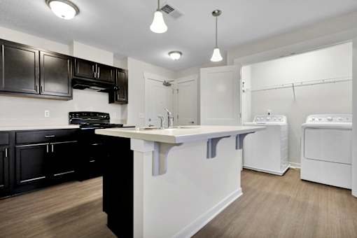 A kitchen with black cabinets and white appliances.