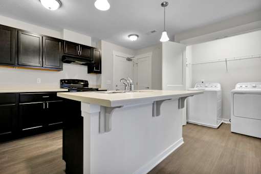 A kitchen with black cabinets and white appliances.