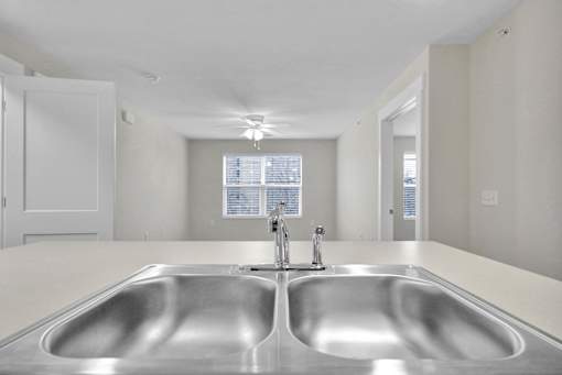 A modern kitchen with a double sink and a window.