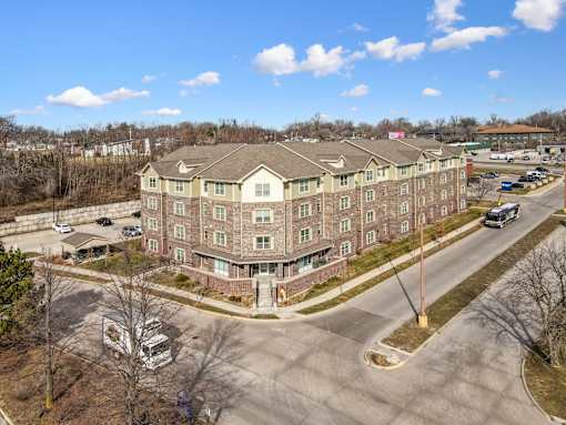 A large apartment complex with a parking lot in front.