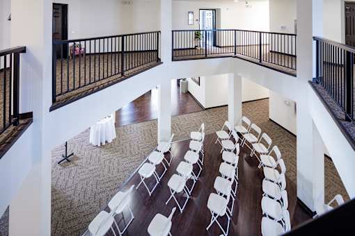 A room with a balcony and a long table with chairs.