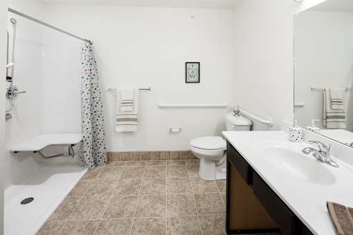 A bathroom with a toilet, sink, and shower.