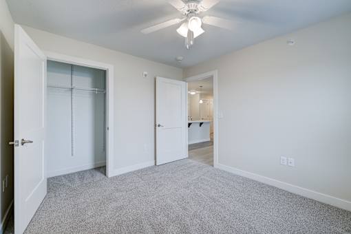A room with a ceiling fan and a carpeted floor.