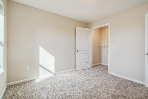 A room with a carpeted floor and a white door.