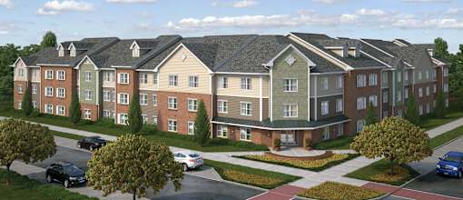 A large apartment complex with a parking lot in front.