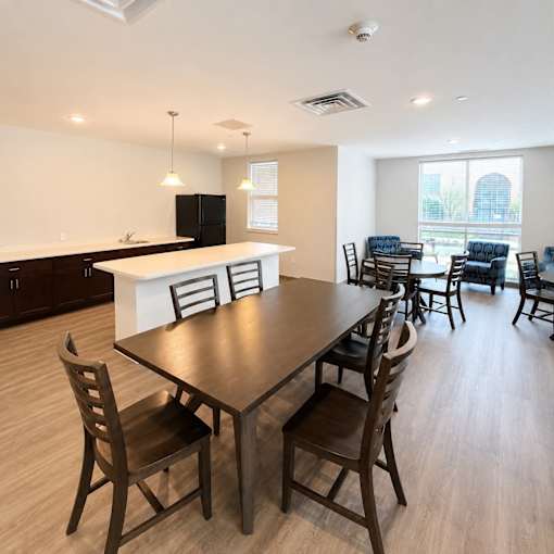A dining room with a table and chairs.